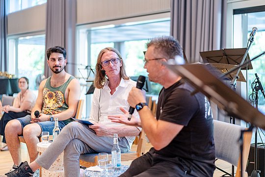 drei Männer führen ein Gespräch